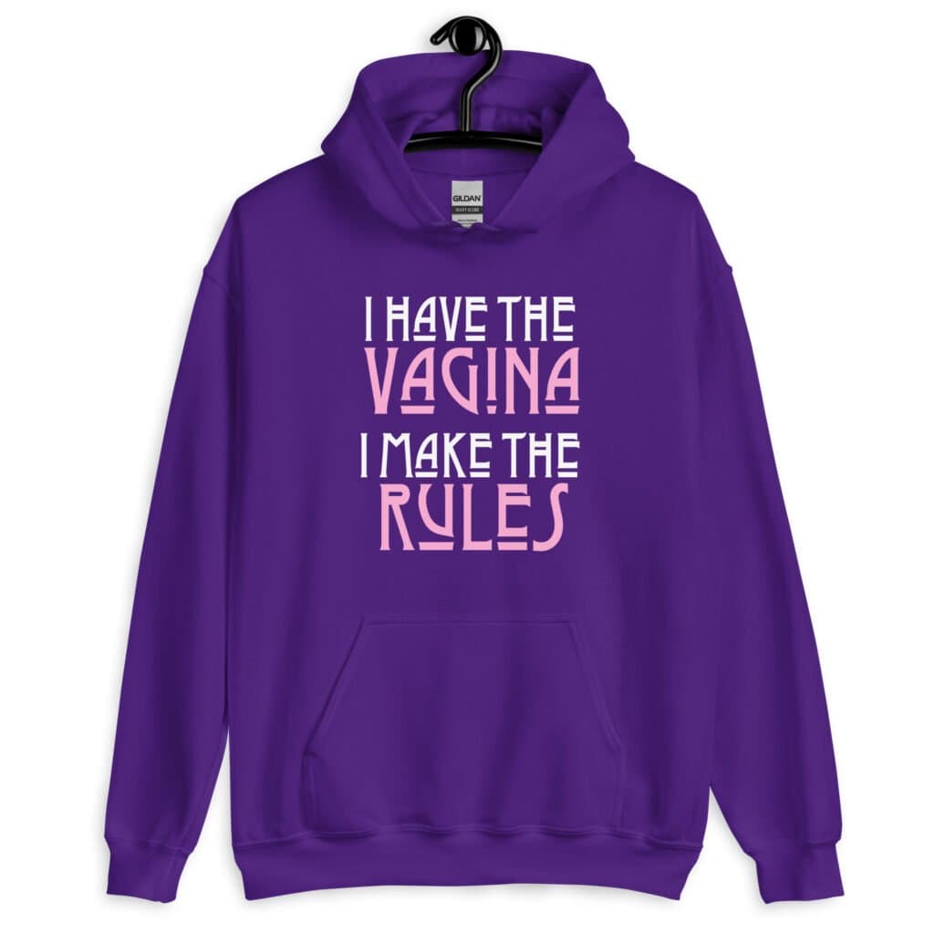 Purple hoodie sweatshirt with the text 'I have the vagina. I make the rules' printed on the front.
