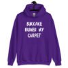 Purple hoodie sweatshirt with the text 'Bukkake ruined my carpet' in drippy font printed on the front.