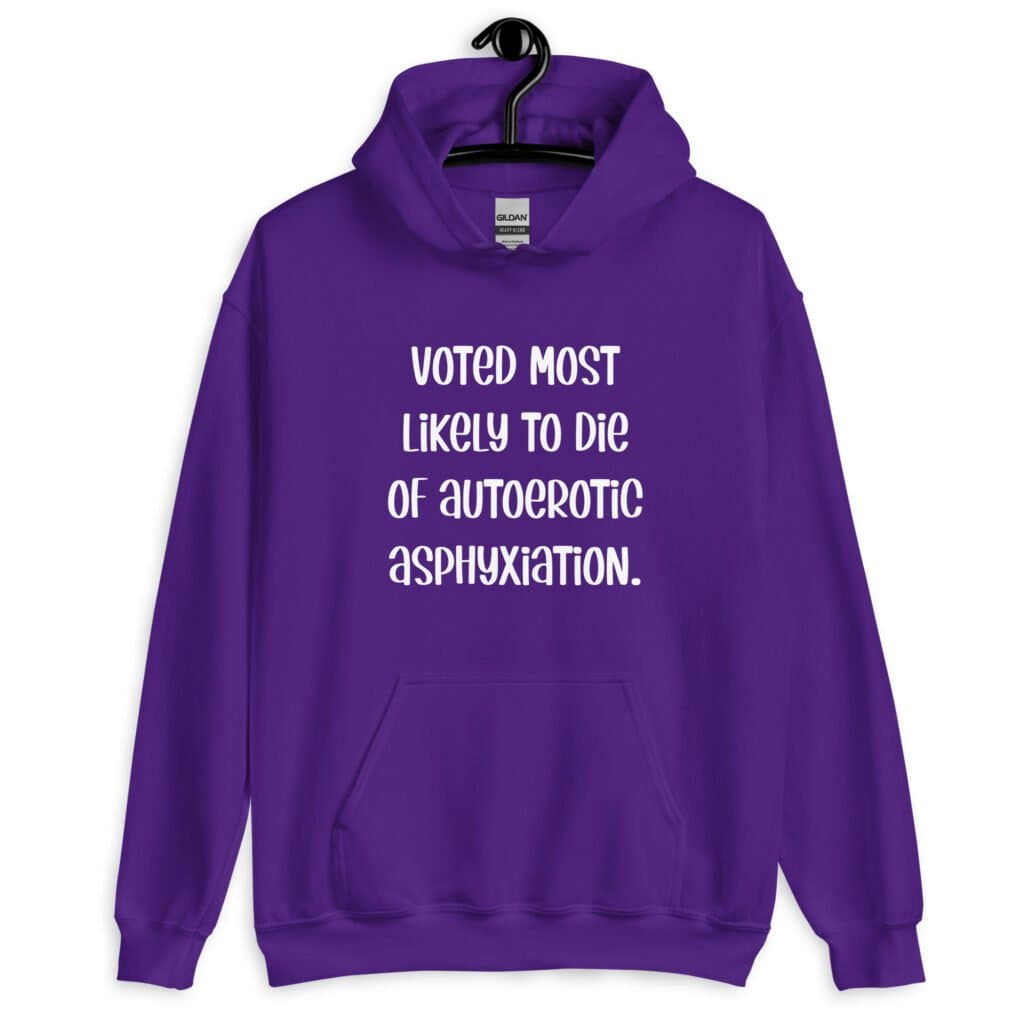 Purple hoodie sweatshirt with the hood up covering some of her face. The hoodie has the text 'Voted most likely to die of autoerotic asphyxiation.' printed on the front.
