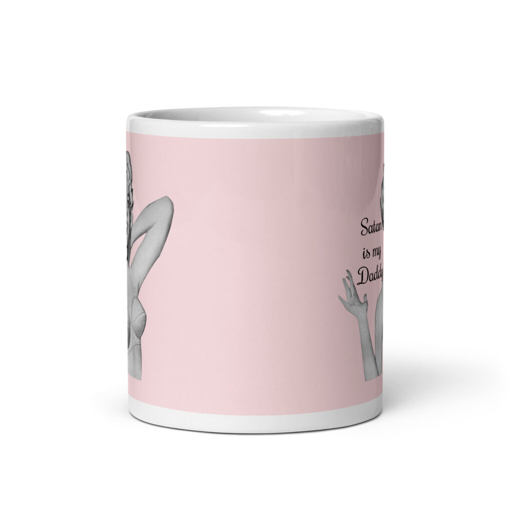 Pink and white ceramic coffee mug with an image of a retro black & white pin-up model and the text 'Satan is my Daddy' printed on both sides.