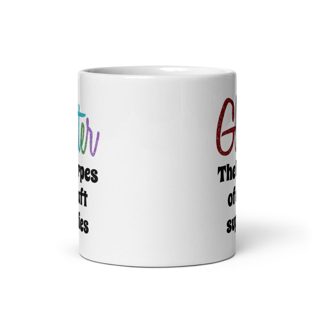 White ceramic coffee mug with the text 'Glitter the herpes of craft supplies' printed on both sides. The word Glitter is printed in multi colored font that looks like glitter.