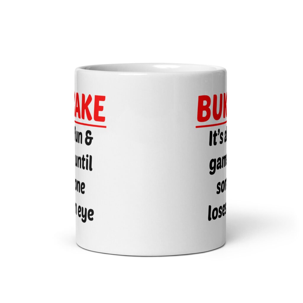 White ceramic mug with the text 'Bukkake. It's all fun & games until someone loses an eye' printed on both sides.