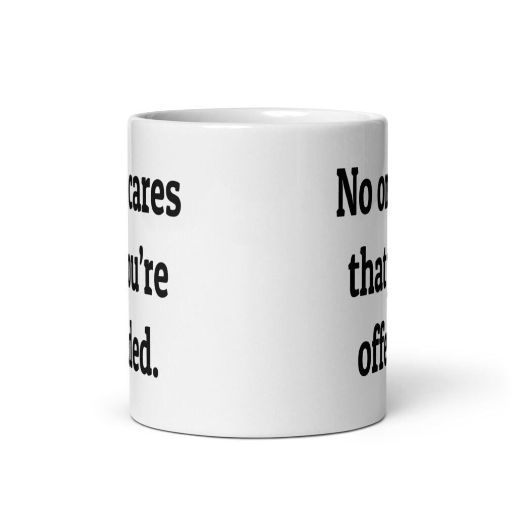 White ceramic coffee mug with the text "No one cares that you're offended.' printed on both sides.