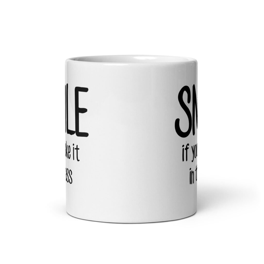 White ceramic mug with the text 'Smile if you take it in the ass' printed on both sides. The word 'smile' is large and the words 'take it in the ass' are much smaller.