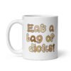 White ceramic coffee mug with the words 'Eat a bag of dicks' printed on both sides. The letters in the words are a penis font and are each a various skin tone.