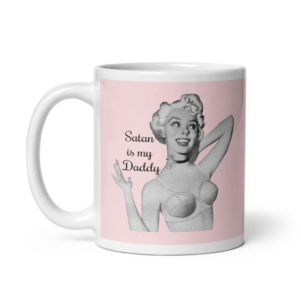 Pink and white ceramic coffee mug with an image of a retro black & white pin-up model and the text 'Satan is my Daddy' printed on both sides.
