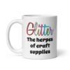 White ceramic coffee mug with the text 'Glitter the herpes of craft supplies' printed on both sides. The word Glitter is printed in multi colored font that looks like glitter.
