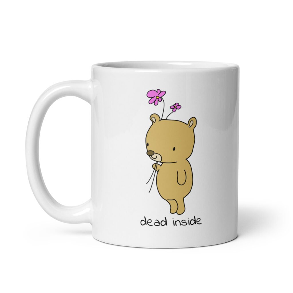 White ceramic coffee mug with an image of a cute bear holding 2 pink flowers. The words 'dead inside' are printed underneath the bear. The graphics are printed on both sides.