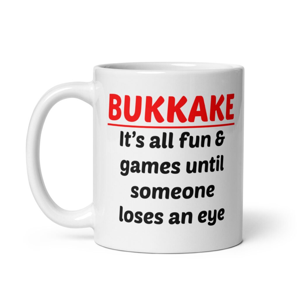 White ceramic mug with the text 'Bukkake. It's all fun & games until someone loses an eye' printed on both sides.