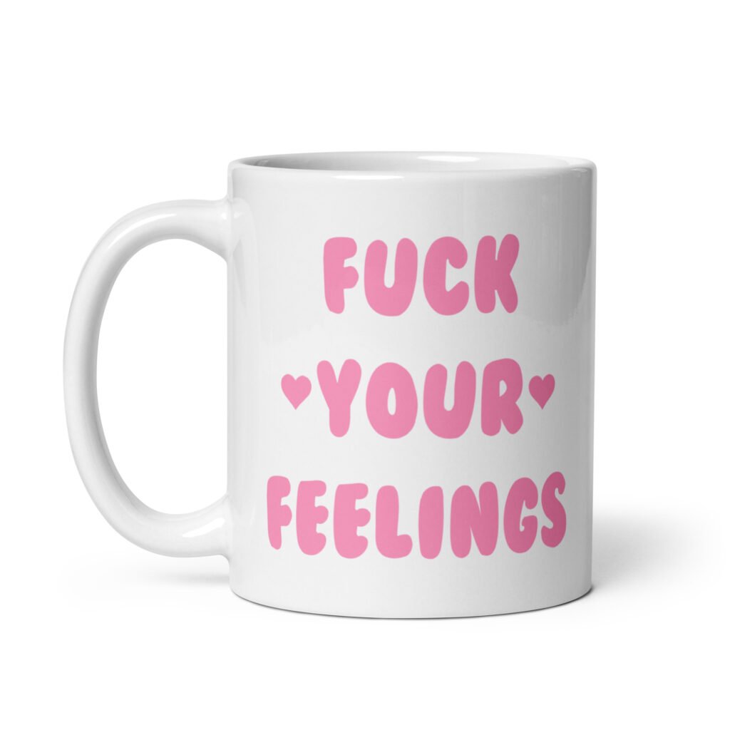 White ceramic coffee mug with the text 'Fuck your feelings' printed on both sides in pink. There are cute pink hearts next to the words.