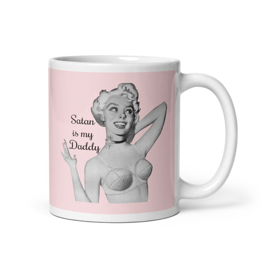 Pink and white ceramic coffee mug with an image of a retro black & white pin-up model and the text 'Satan is my Daddy' printed on both sides.