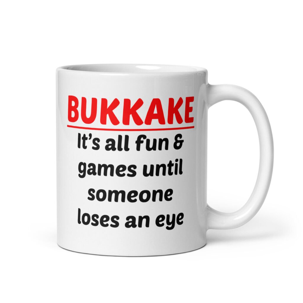 White ceramic mug with the text 'Bukkake. It's all fun & games until someone loses an eye' printed on both sides.