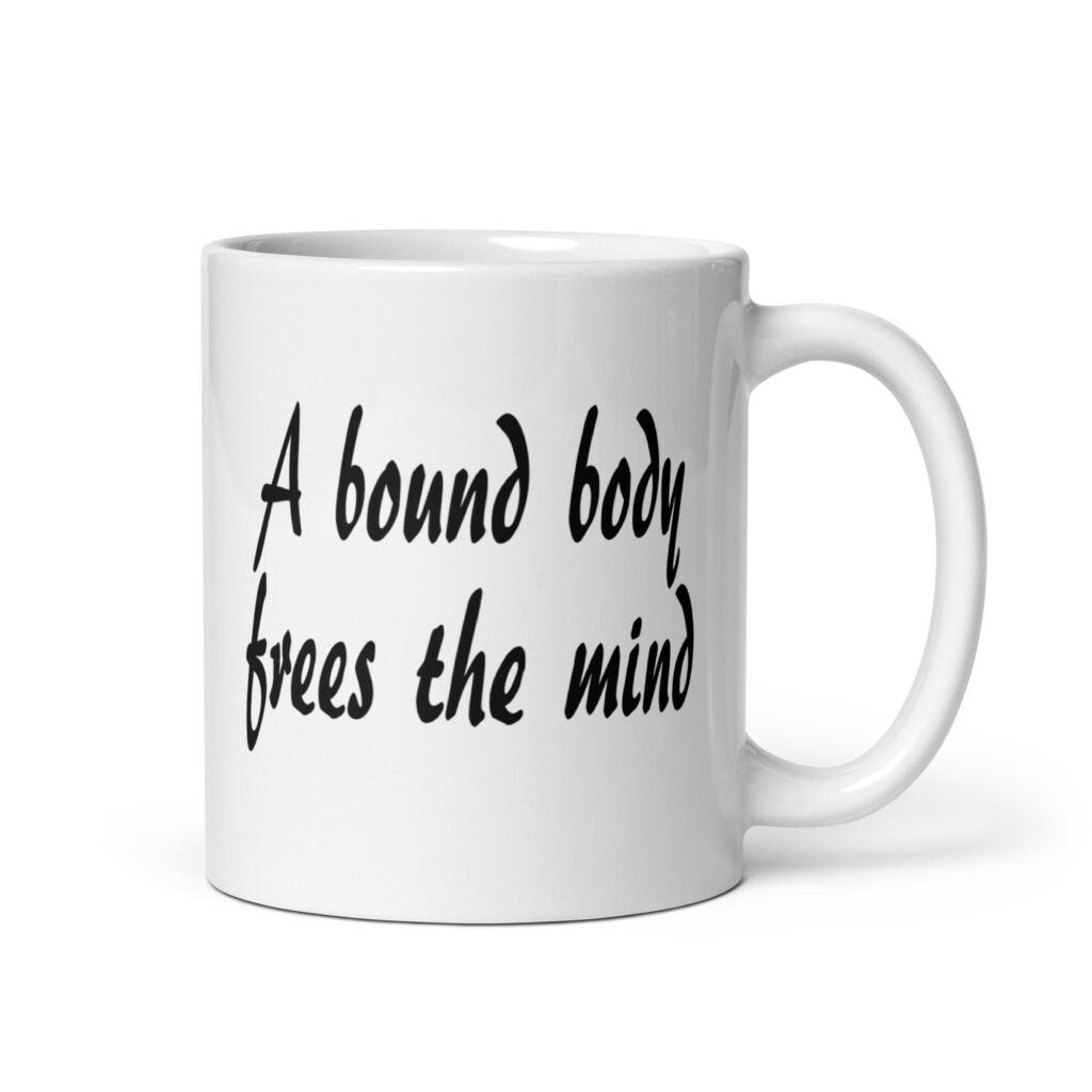 White ceramic coffee mug with the text 'A bound body frees the mind' printed on both sides.