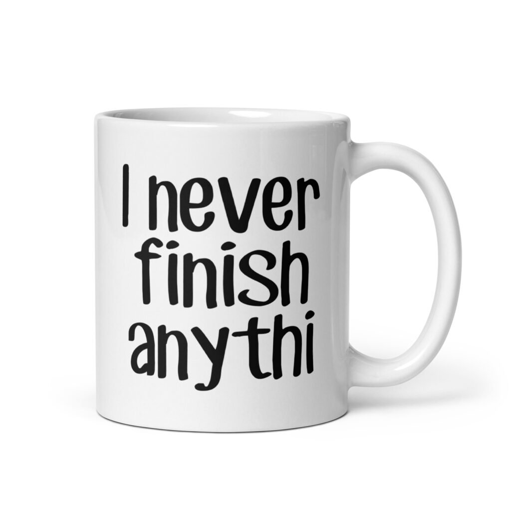 White ceramic coffee mug with the text 'I never finish anyth' printed on both sides.