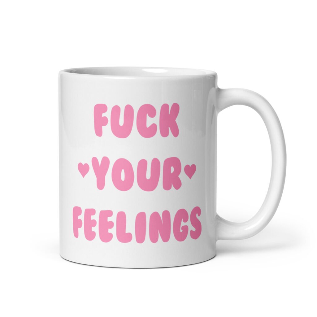White ceramic coffee mug with the text 'Fuck your feelings' printed on both sides in pink. There are cute pink hearts next to the words.