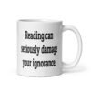 White ceramic coffee mug with the text 'Reading can seriously damage your ignorance.' printed on both sides.