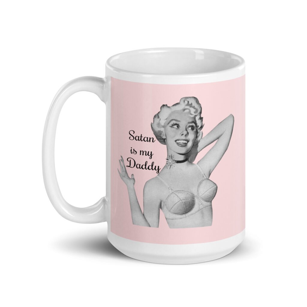 Pink and white ceramic coffee mug with an image of a retro black & white pin-up model and the text 'Satan is my Daddy' printed on both sides.