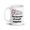 White ceramic coffee mug with the text 'Glitter the herpes of craft supplies' printed on both sides. The word Glitter is printed in multi colored font that looks like glitter.