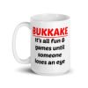 White ceramic mug with the text 'Bukkake. It's all fun & games until someone loses an eye' printed on both sides.