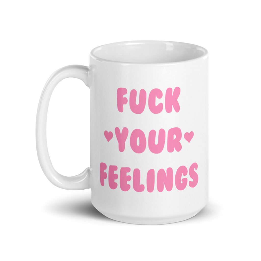 White ceramic coffee mug with the text 'Fuck your feelings' printed on both sides in pink. There are cute pink hearts next to the words.