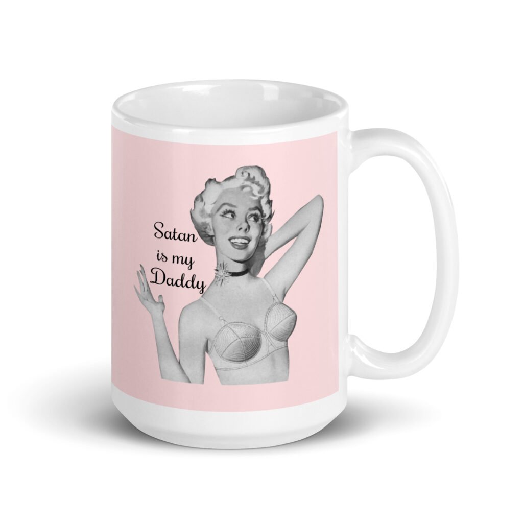 Pink and white ceramic coffee mug with an image of a retro black & white pin-up model and the text 'Satan is my Daddy' printed on both sides.