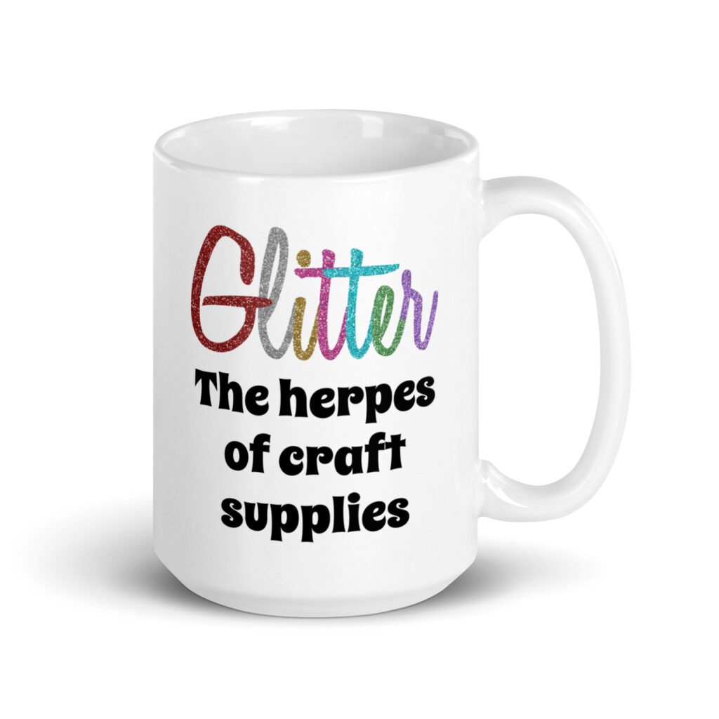 White ceramic coffee mug with the text 'Glitter the herpes of craft supplies' printed on both sides. The word Glitter is printed in multi colored font that looks like glitter.
