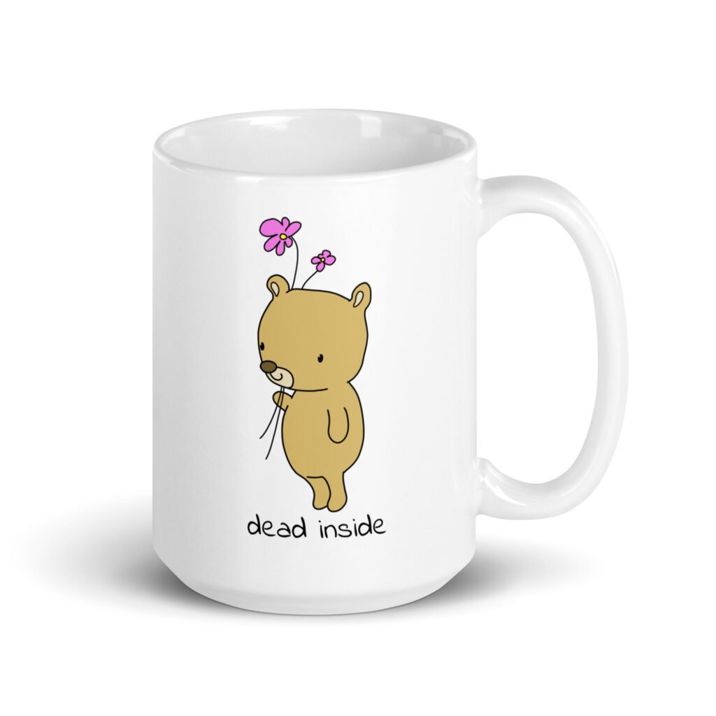 White ceramic coffee mug with an image of a cute bear holding 2 pink flowers. The words 'dead inside' are printed underneath the bear. The graphics are printed on both sides.
