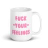 White ceramic coffee mug with the text 'Fuck your feelings' printed on both sides in pink. There are cute pink hearts next to the words.