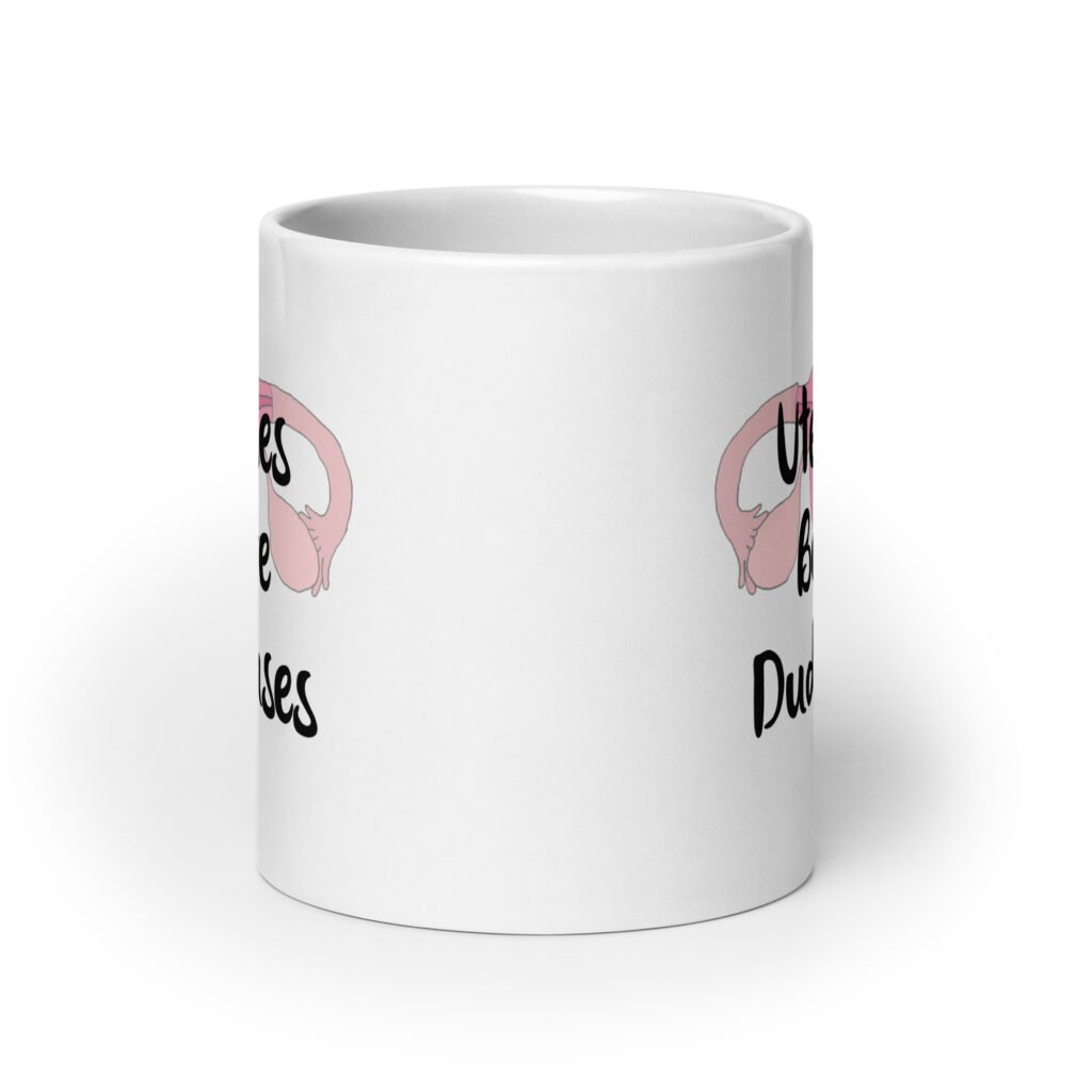 White ceramic mug with image of a uterus and the text 'Uteruses before duderuses' printed on both sides.