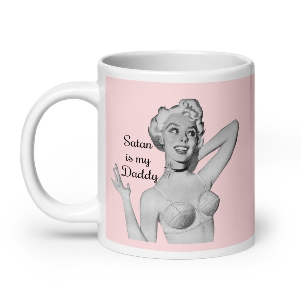 Pink and white ceramic coffee mug with an image of a retro black & white pin-up model and the text 'Satan is my Daddy' printed on both sides.