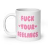 White ceramic coffee mug with the text 'Fuck your feelings' printed on both sides in pink. There are cute pink hearts next to the words.