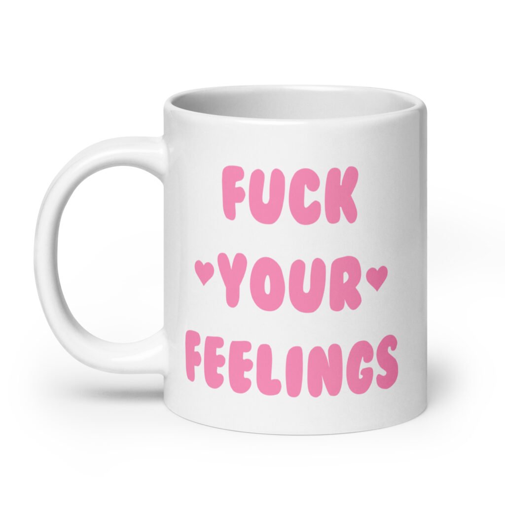 White ceramic coffee mug with the text 'Fuck your feelings' printed on both sides in pink. There are cute pink hearts next to the words.