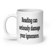 White ceramic coffee mug with the text 'Reading can seriously damage your ignorance.' printed on both sides.