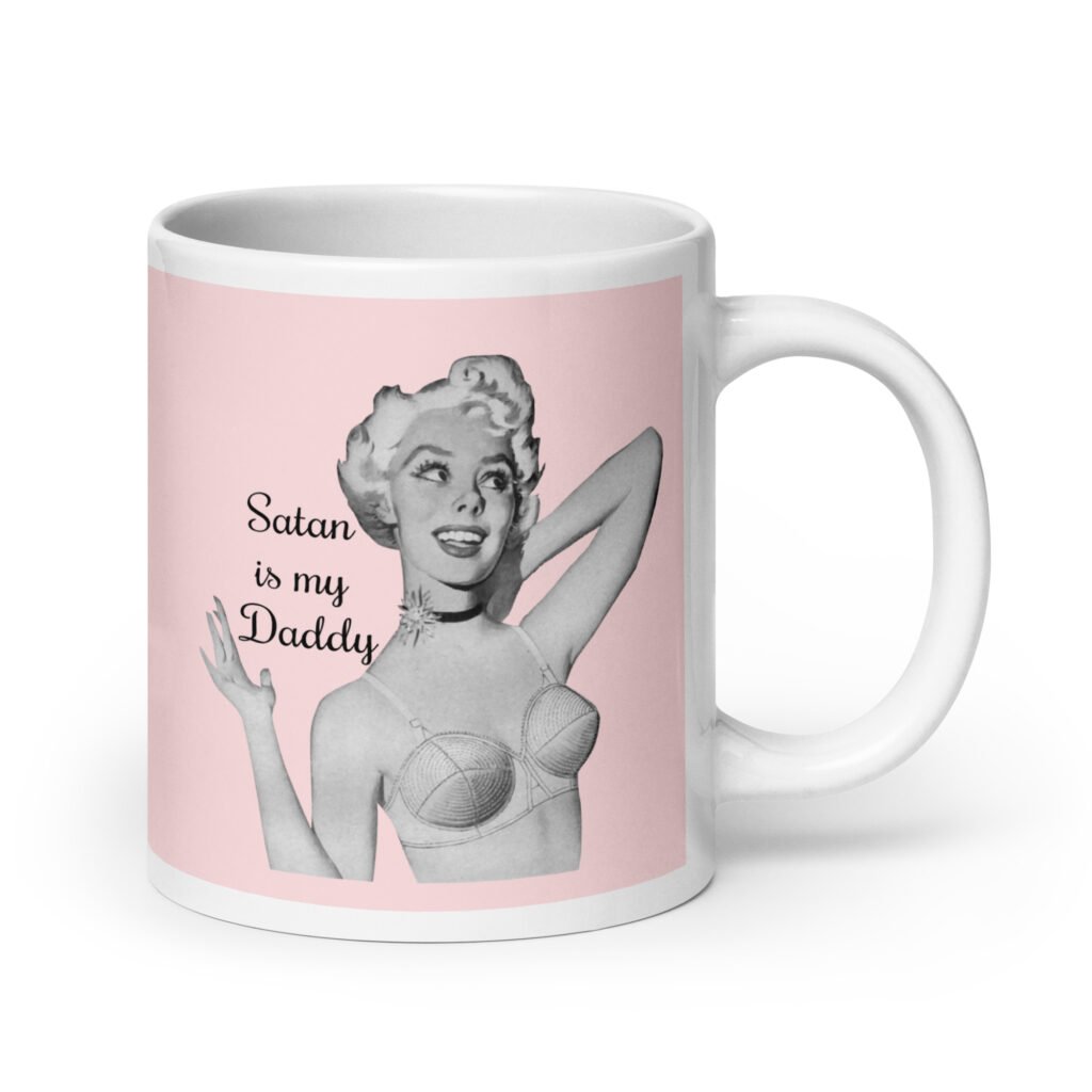 Pink and white ceramic coffee mug with an image of a retro black & white pin-up model and the text 'Satan is my Daddy' printed on both sides.