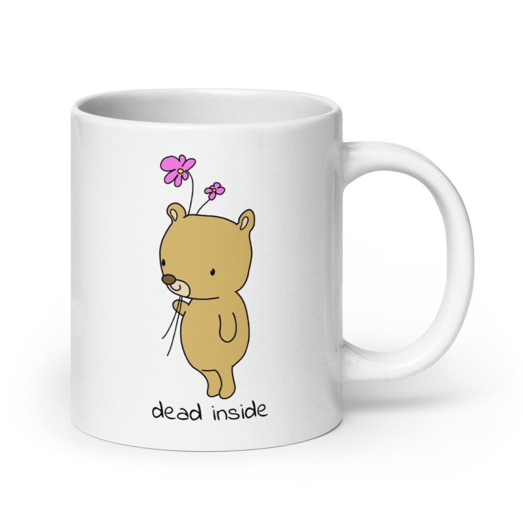 White ceramic coffee mug with an image of a cute bear holding 2 pink flowers. The words 'dead inside' are printed underneath the bear. The graphics are printed on both sides.