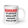 White ceramic mug with the text 'Bukkake. It's all fun & games until someone loses an eye' printed on both sides.