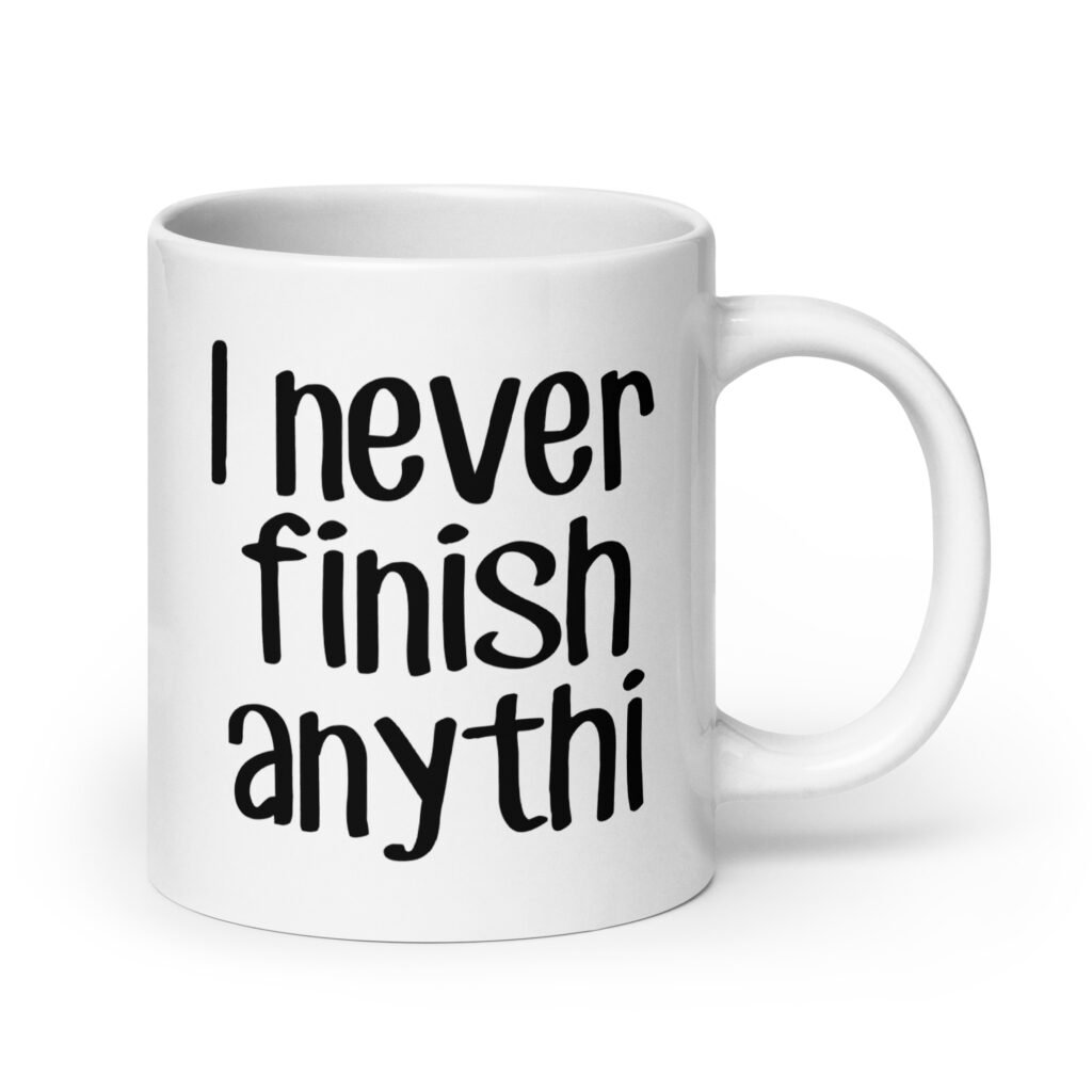 White ceramic coffee mug with the text 'I never finish anyth' printed on both sides.
