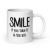White ceramic mug with the text 'Smile if you take it in the ass' printed on both sides. The word 'smile' is large and the words 'take it in the ass' are much smaller.
