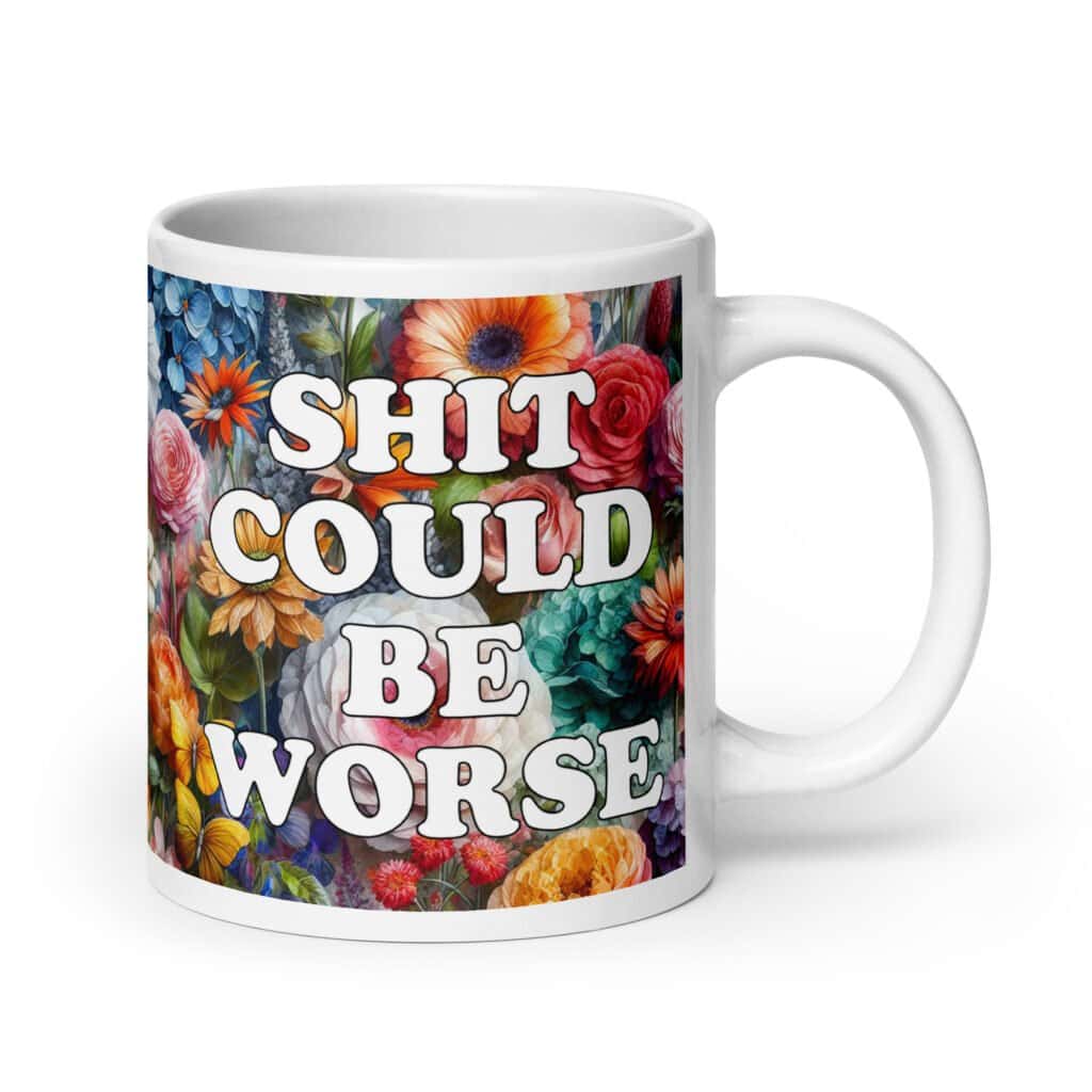 White ceramic mug floral background and the text 'Shit could be worse' printed on both sides.