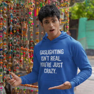 Man wearing a royal blue hoodie sweatshirt with the text 'Gaslighting isn't real. You're just crazy.' printed on the front in bold distressed font.