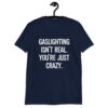 Navy blue t-shirt with the text 'Gaslighting isn't real. You're just crazy.' printed on the front in bold distressed font.