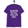 Purple t-shirt with the text 'Gaslighting isn't real. You're just crazy.' printed on the front in bold distressed font.