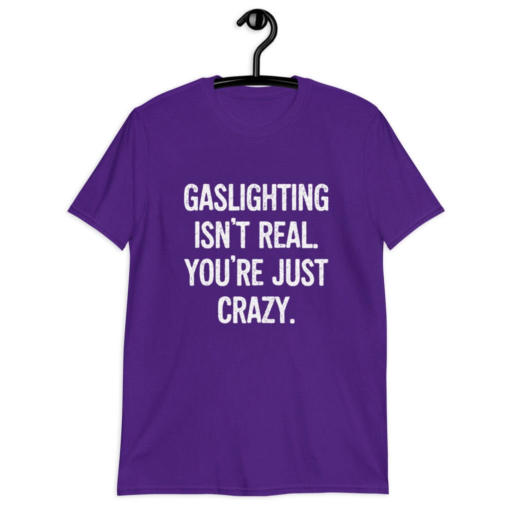Purple t-shirt with the text 'Gaslighting isn't real. You're just crazy.' printed on the front in bold distressed font.