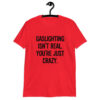 Red t-shirt with the text 'Gaslighting isn't real. You're just crazy.' printed on the front in bold distressed font.