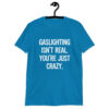 Sapphire blue t-shirt with the text 'Gaslighting isn't real. You're just crazy.' printed on the front in bold distressed font.