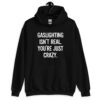Black hoodie sweatshirt with the text 'Gaslighting isn't real. You're just crazy.' printed on the front in bold distressed font.