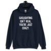 Navy blue hoodie sweatshirt with the text 'Gaslighting isn't real. You're just crazy.' printed on the front in bold distressed font.
