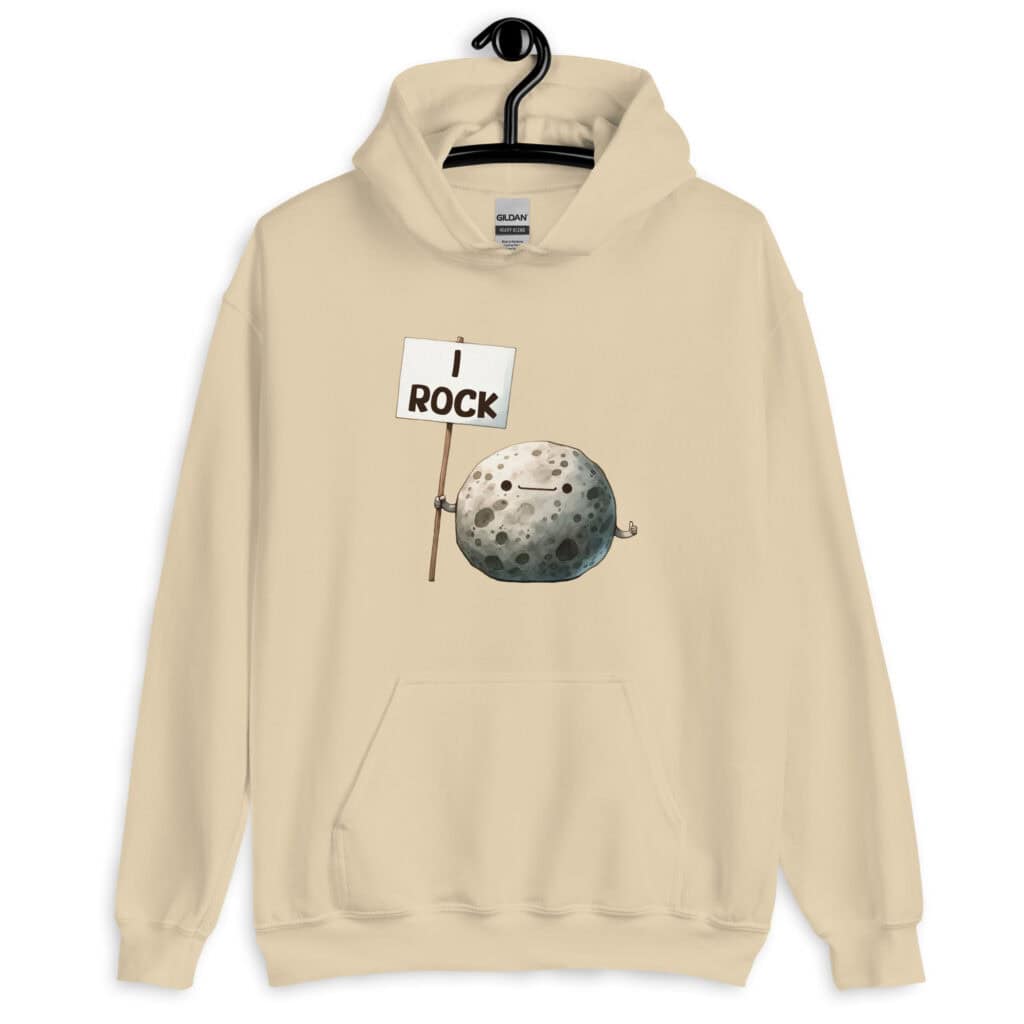 Sand color hoodie sweatshirt that has an image of a grey rock that is holding a sign. The sign says 'I Rock.' The image is printed on the front of the hoodie.
