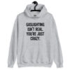 Sport grey hoodie sweatshirt with the text 'Gaslighting isn't real. You're just crazy.' printed on the front in bold distressed font.