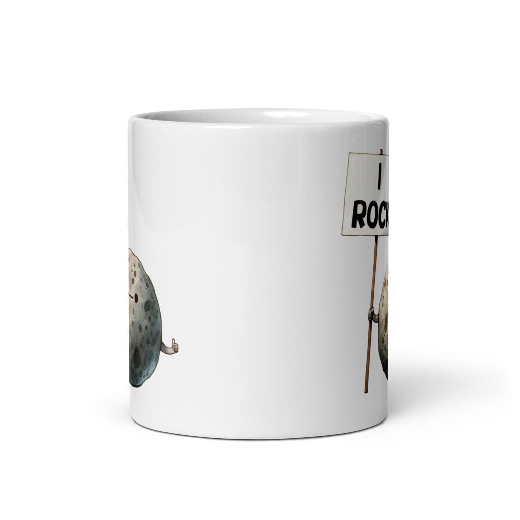 White ceramic mug that has an image of a grey rock that is holding a sign. The sign says 'I Rock.' The image is printed on both sides of the mug.
